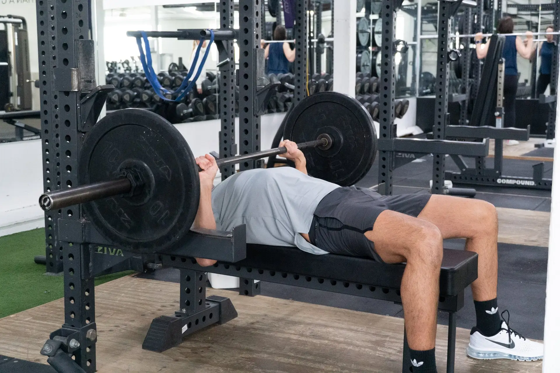 A man performs a bench press with a barbell at Catalyst Training Co. gym in Randwick.