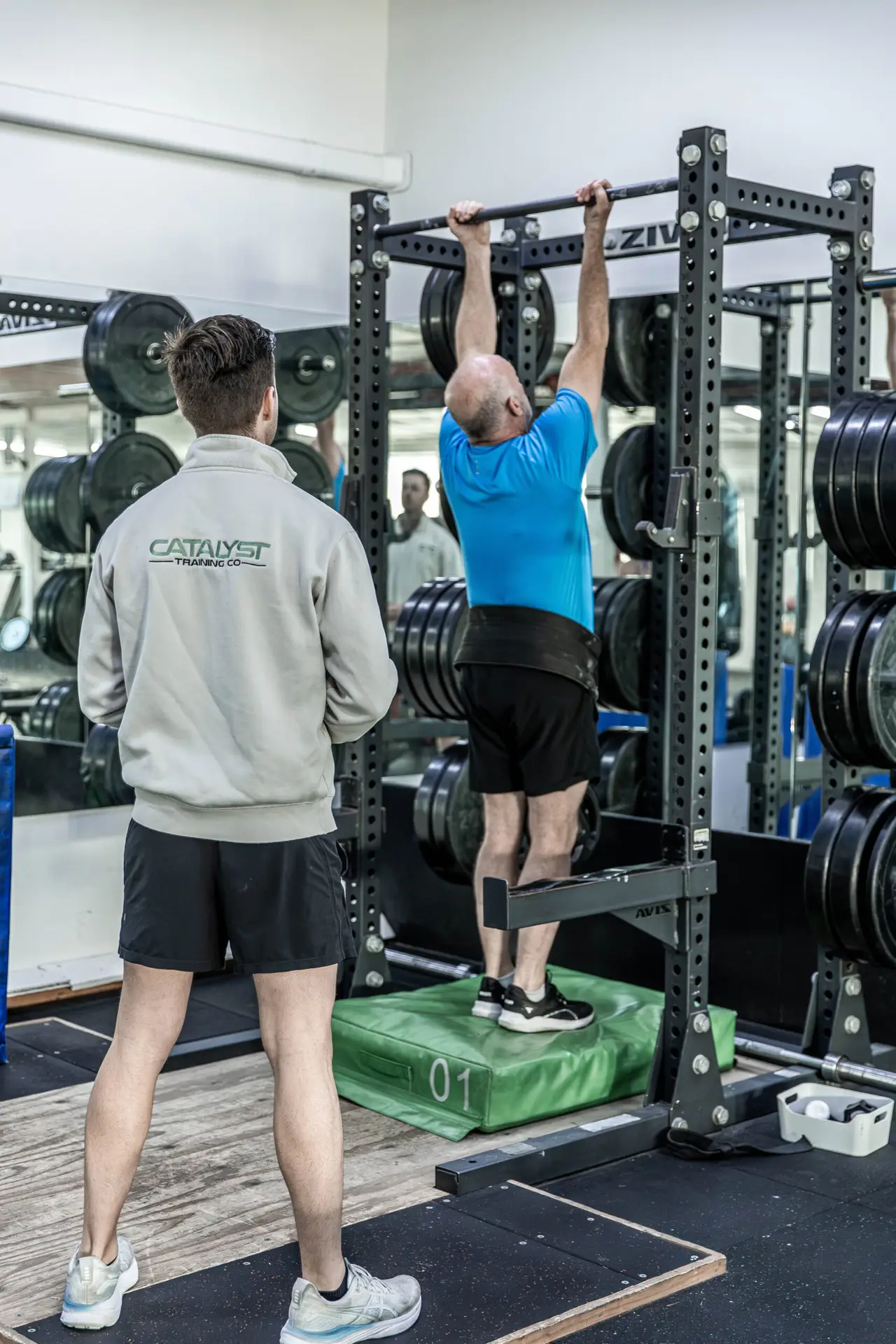 A Catalyst coach watching a client during 1RM strength testing in Randwick