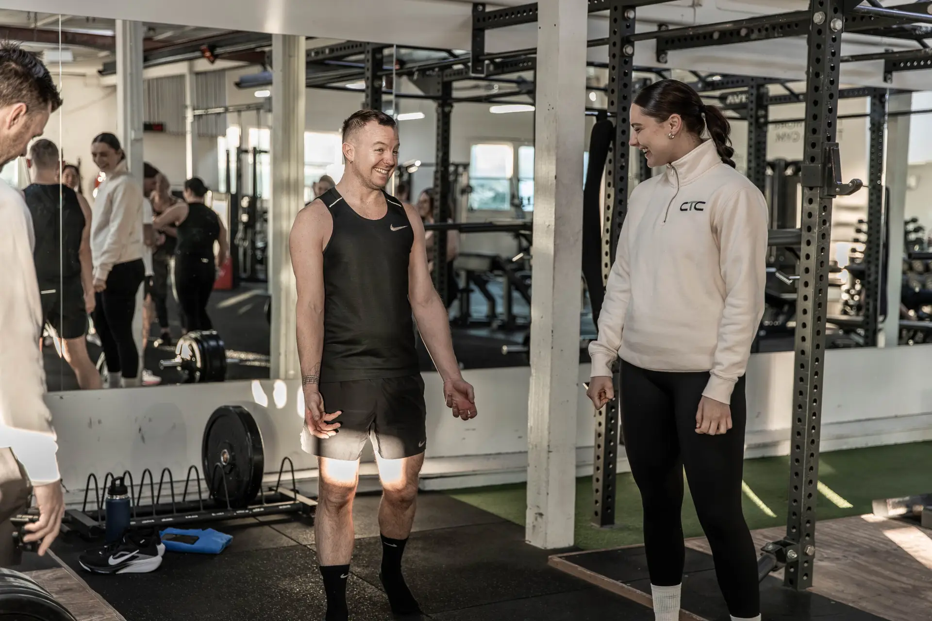 A Catalyst coach talking with a member between sets on the gym floor