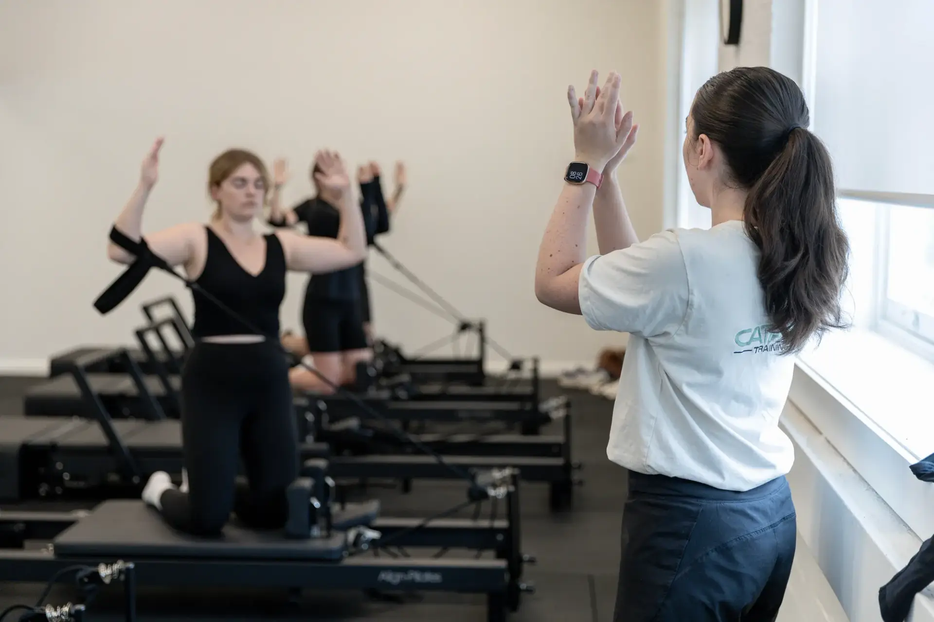 Instructor cueing a client through physio led reformer Pilates